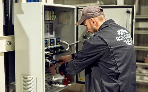 Рабочий за сборкой щита управления АСМ-РМ4